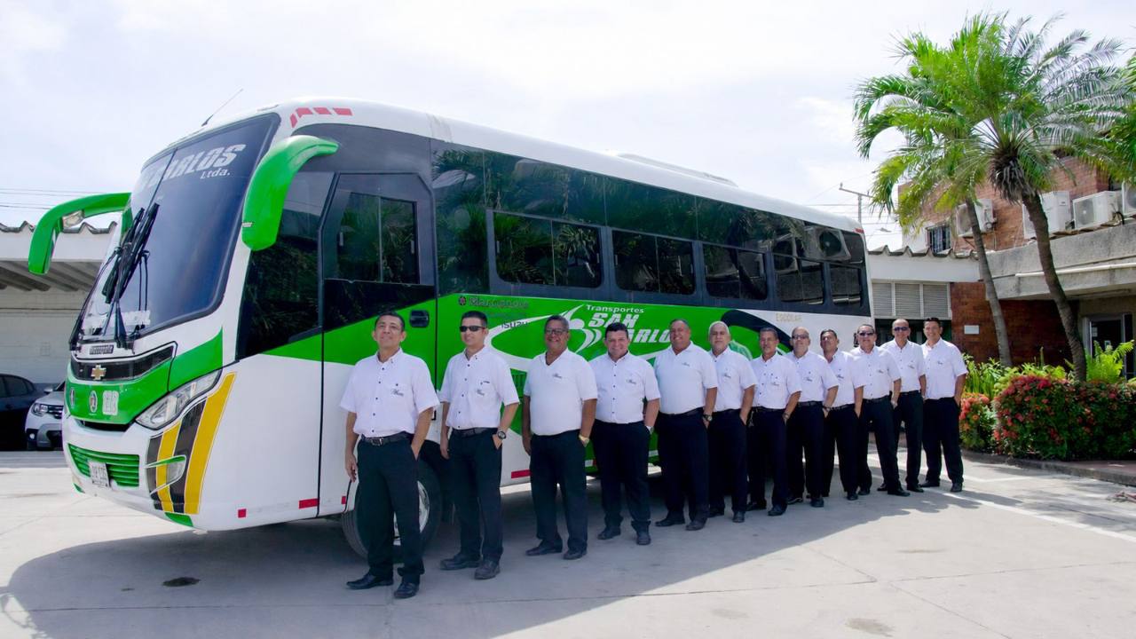 Equipo operativo de Transportes San Carlos junto a uno de sus buses